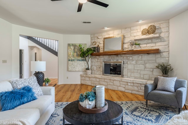 living room with a fireplace, ceiling fan, and hardwood / wood-style floors