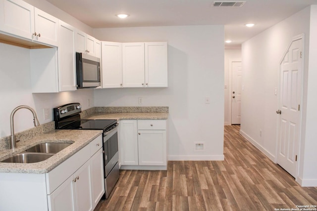 kitchen with white cabinets, light stone counters, sink, and stainless steel appliances