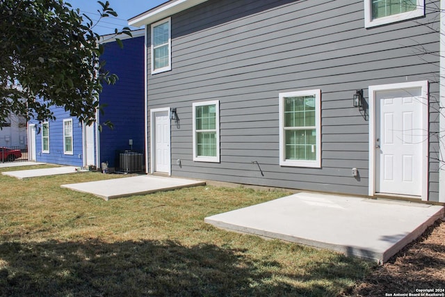 back of property with a patio, cooling unit, and a lawn