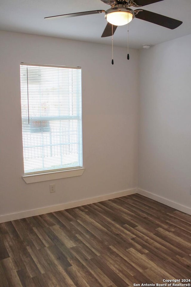 empty room featuring plenty of natural light and dark hardwood / wood-style floors