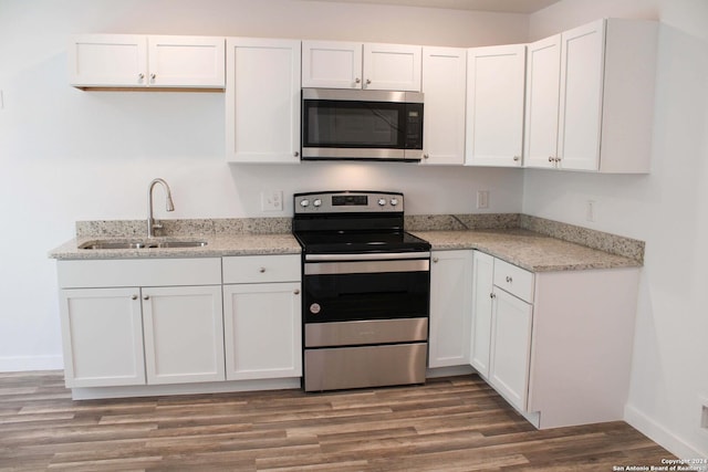 kitchen featuring dark hardwood / wood-style flooring, white cabinetry, sink, and appliances with stainless steel finishes