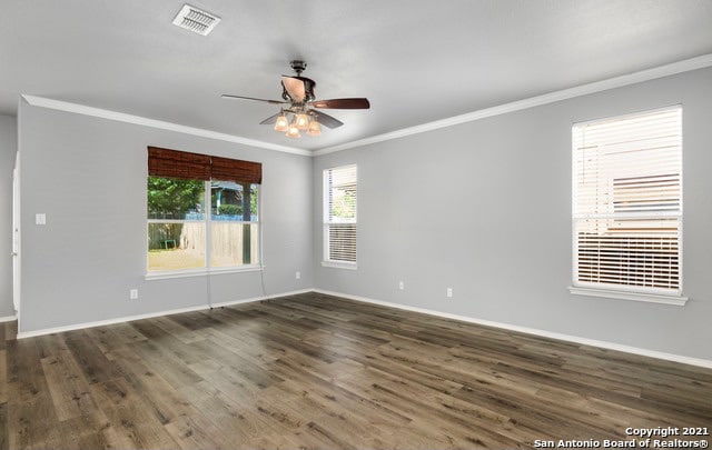 spare room featuring ceiling fan, dark hardwood / wood-style flooring, and a wealth of natural light