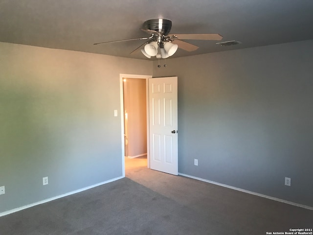 carpeted spare room featuring ceiling fan