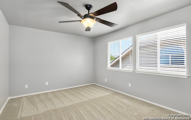 empty room with light colored carpet and ceiling fan