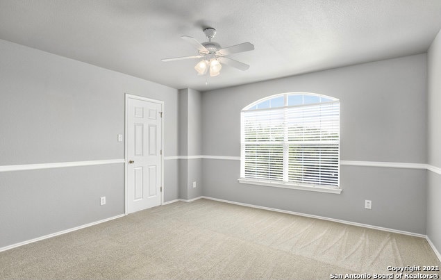 unfurnished room with carpet and ceiling fan