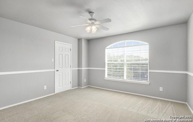 unfurnished room with ceiling fan, carpet flooring, and baseboards