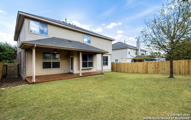 rear view of property featuring a fenced backyard, a yard, and a patio