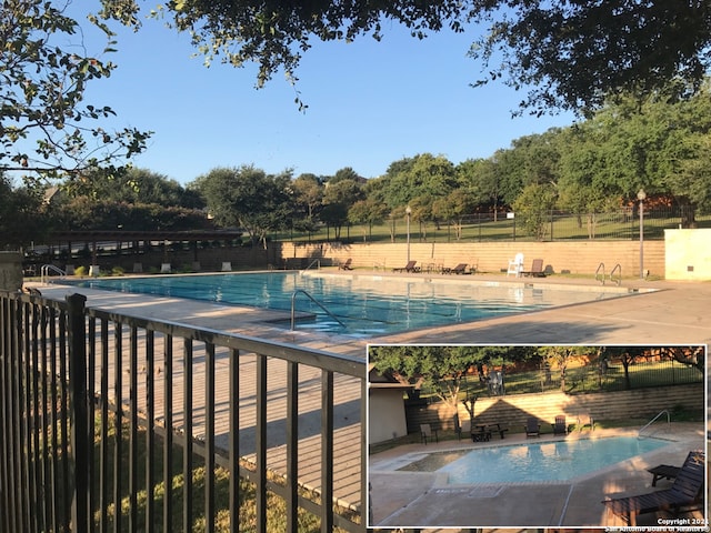 pool with a patio and fence