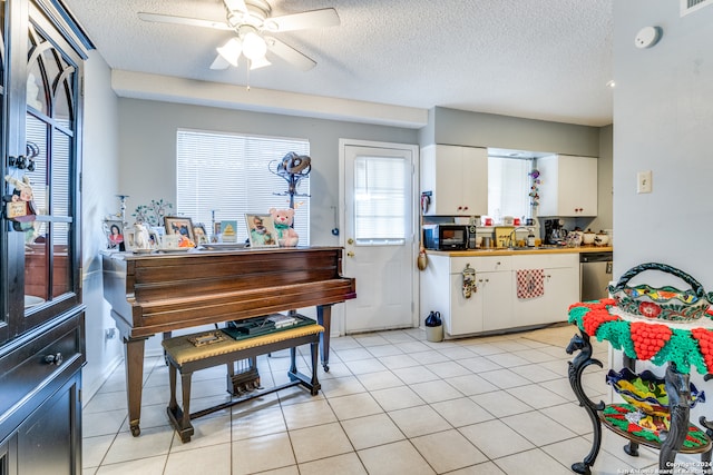 kitchen featuring white cabinets, light tile patterned floors, stainless steel dishwasher, a textured ceiling, and ceiling fan