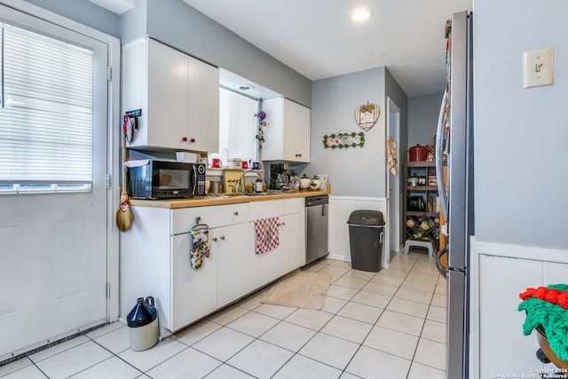 kitchen featuring plenty of natural light, appliances with stainless steel finishes, and white cabinetry