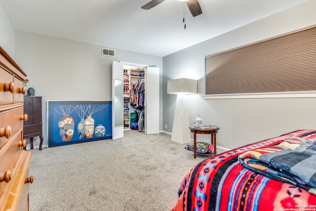 carpeted bedroom with ceiling fan, a closet, and a spacious closet