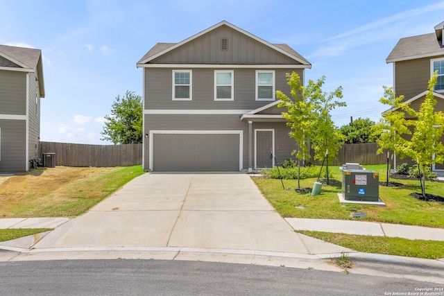 traditional-style home with board and batten siding, fence, concrete driveway, and a front yard