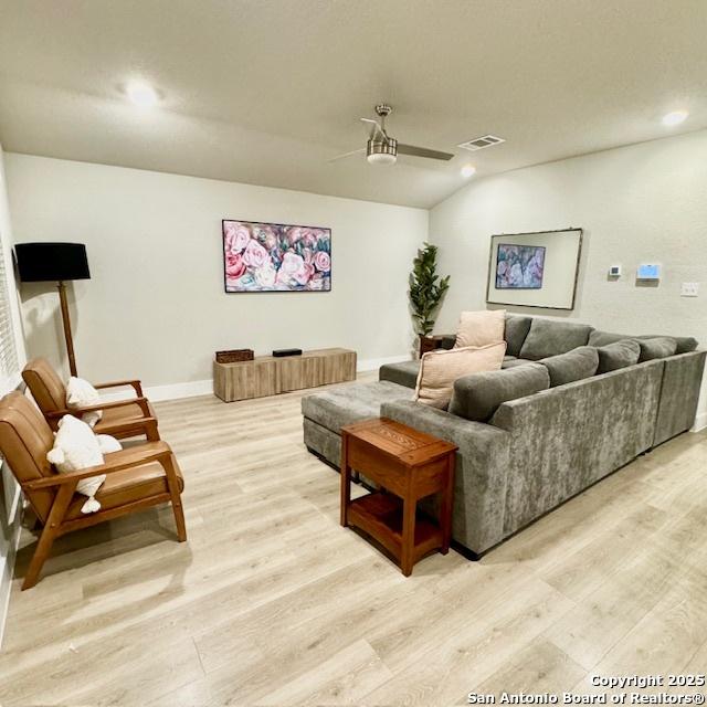 living room with ceiling fan and light hardwood / wood-style flooring