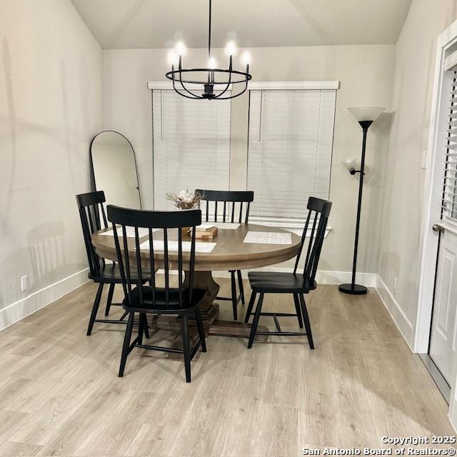 dining space with a chandelier and light wood-type flooring