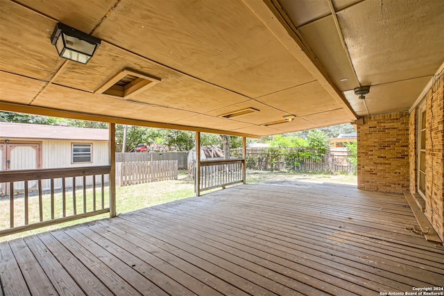 wooden deck with a lawn and an outbuilding