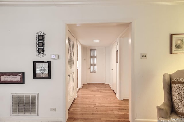 hall featuring light hardwood / wood-style floors and ornamental molding