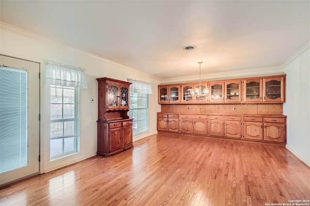 dining room featuring light wood-type flooring, an inviting chandelier, and crown molding