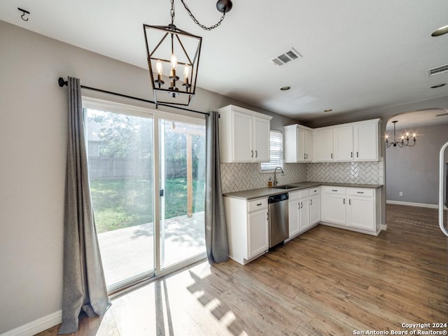 kitchen featuring white cabinetry, tasteful backsplash, decorative light fixtures, dishwasher, and a chandelier