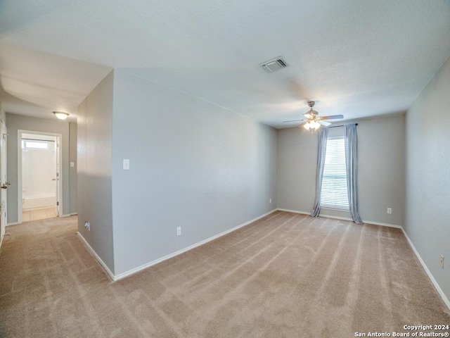 carpeted spare room with ceiling fan