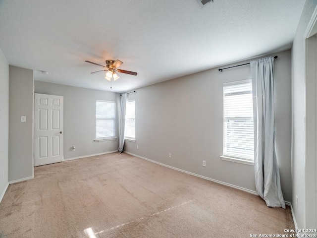 spare room featuring ceiling fan and light colored carpet