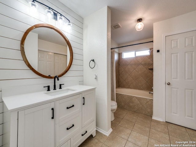 full bathroom featuring toilet, tiled shower / bath combo, tile patterned floors, and vanity