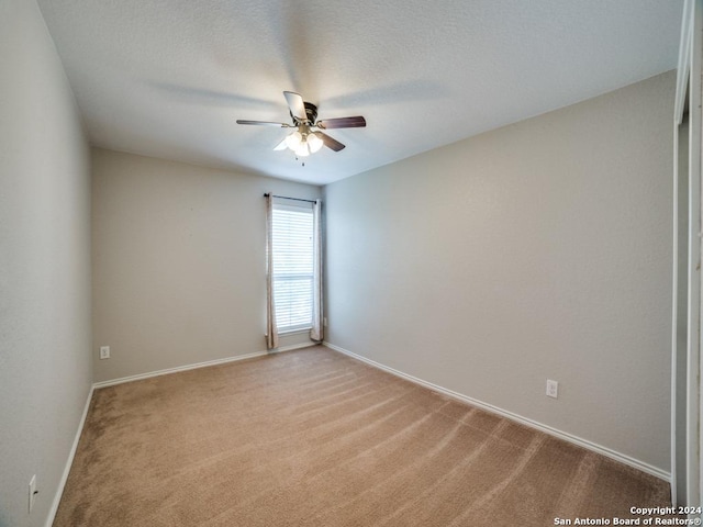 spare room with ceiling fan and light colored carpet