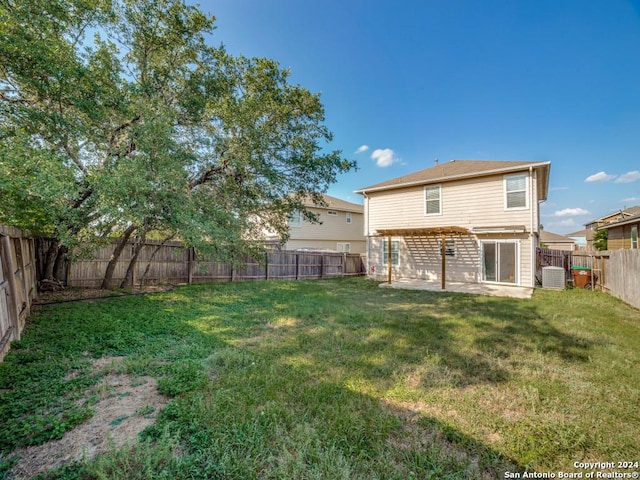 rear view of property featuring a lawn, central AC unit, and a patio