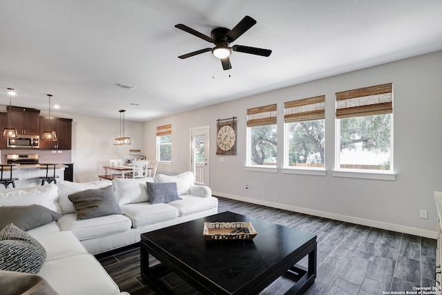 living room featuring plenty of natural light, dark hardwood / wood-style floors, and ceiling fan