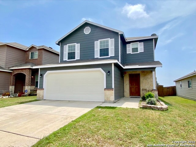 view of front of property featuring a garage and a front lawn