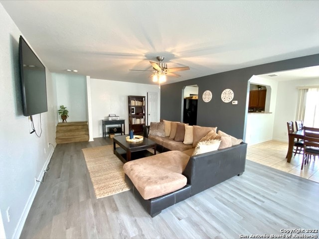 25231 Cambridge Wl, San Antonio, TX 78261 - living area featuring arched walkways, ceiling fan, baseboards, and light wood-style floors