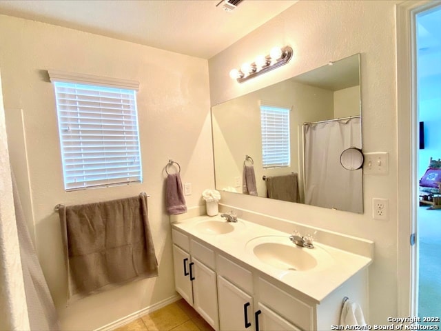 bathroom featuring tile patterned flooring and dual vanity