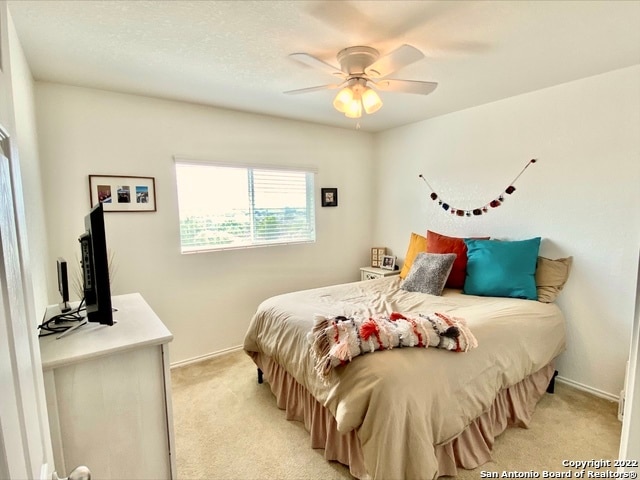 bedroom with light colored carpet and ceiling fan