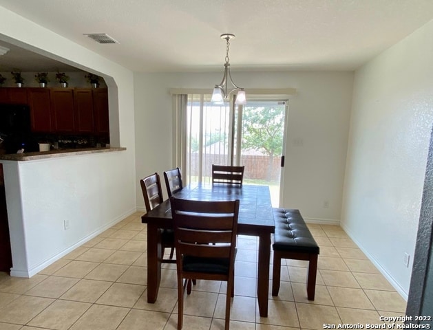 dining space with a chandelier and light tile patterned floors