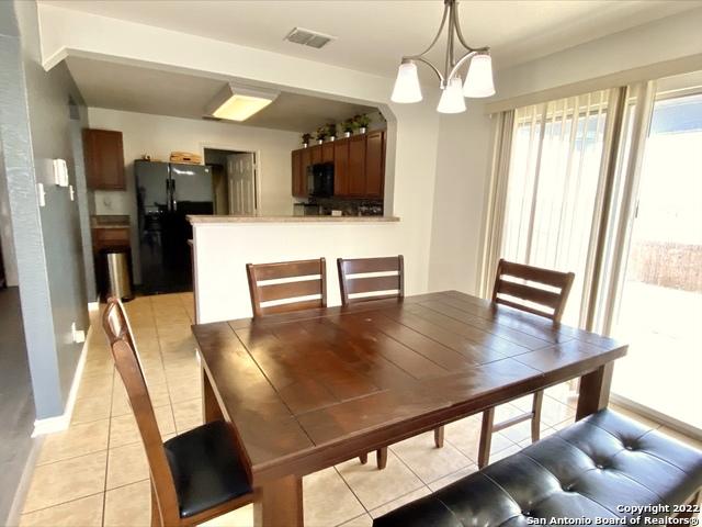 25231 Cambridge Wl, San Antonio, TX 78261 - dining room with a chandelier, light tile patterned floors, and baseboards