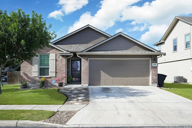 view of front of house featuring a garage, central air condition unit, and a front yard