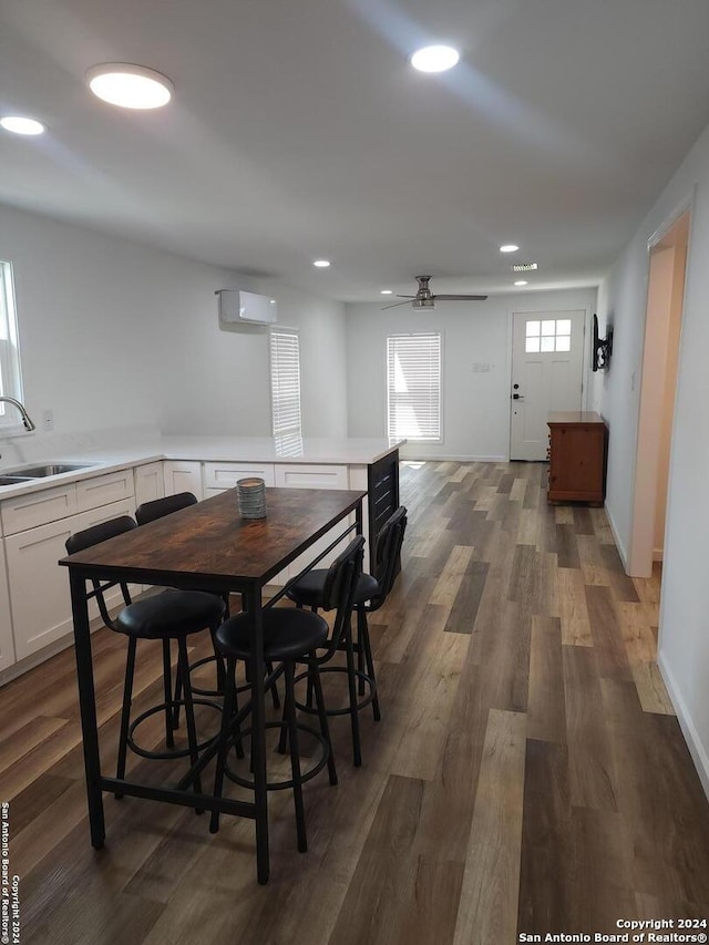 648 S 9th, Aransas Pass, TX 78336 - dining room with a ceiling fan, dark wood-style flooring, recessed lighting, a wall unit AC, and baseboards