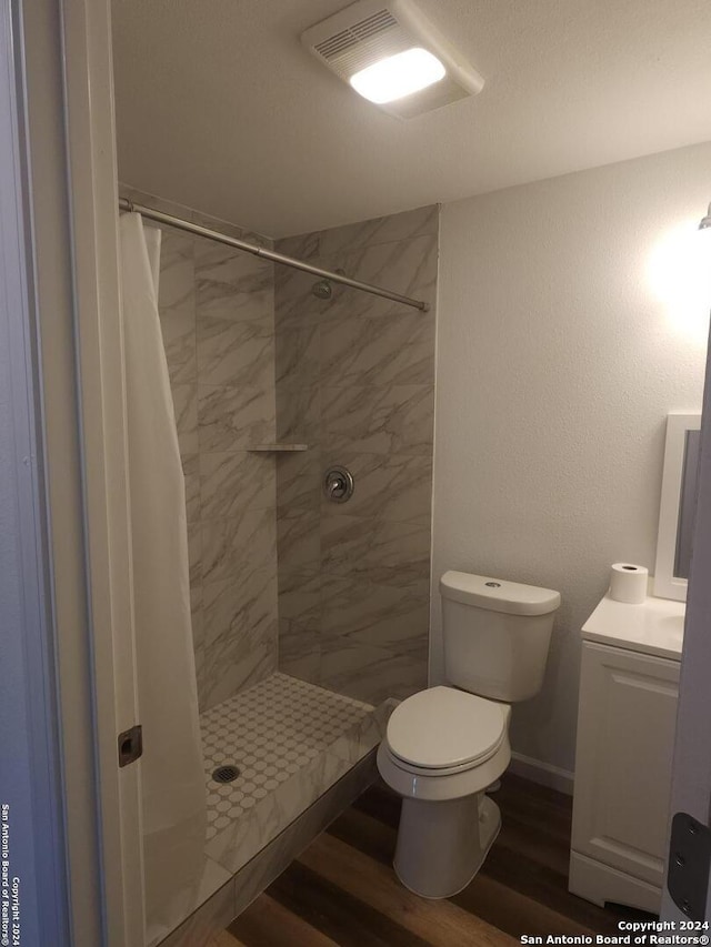 bathroom with hardwood / wood-style flooring, toilet, vanity, and a shower with shower curtain