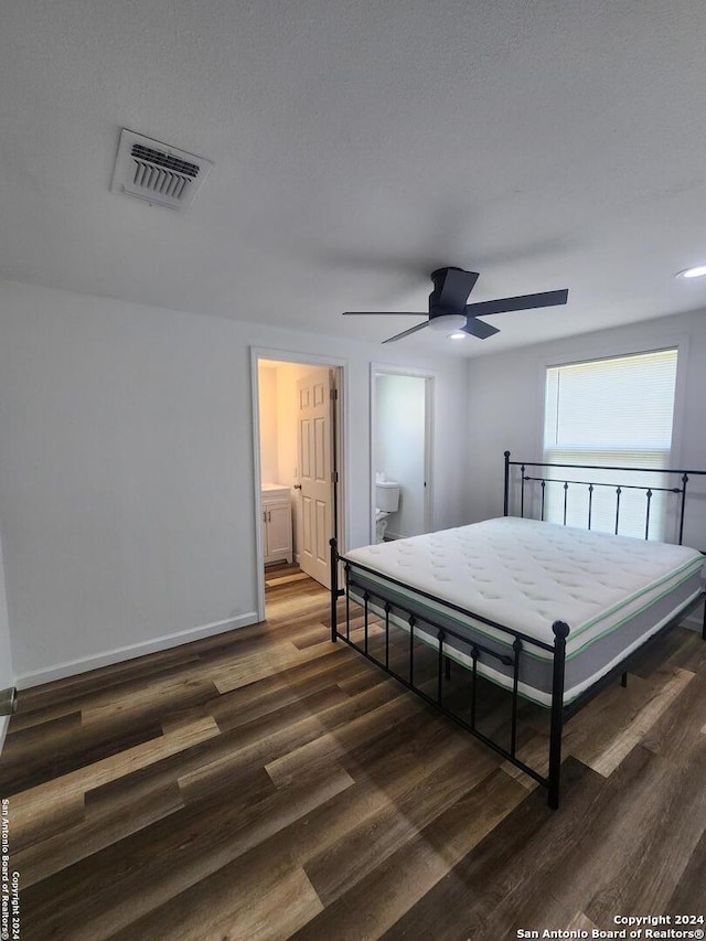 bedroom featuring dark hardwood / wood-style floors, connected bathroom, and ceiling fan