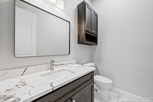 bathroom featuring tile patterned flooring, vanity, and toilet