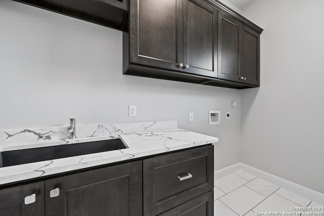 laundry room with cabinets, hookup for an electric dryer, washer hookup, sink, and light tile patterned floors