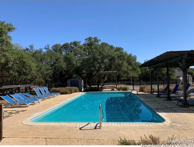 view of pool with a storage unit and a patio area