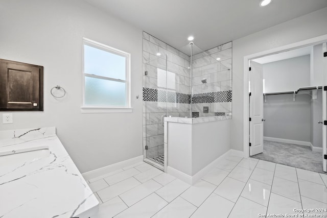 bathroom featuring tile patterned floors, vanity, and tiled shower