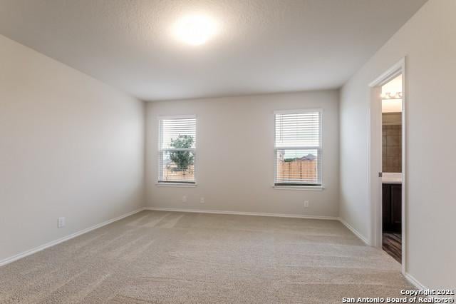 carpeted empty room with a textured ceiling