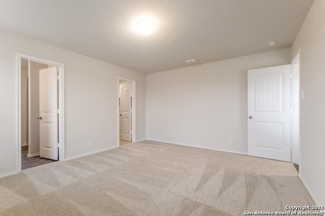 unfurnished bedroom with light colored carpet