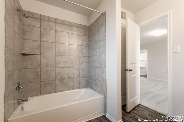 bathroom featuring hardwood / wood-style flooring and tiled shower / bath combo