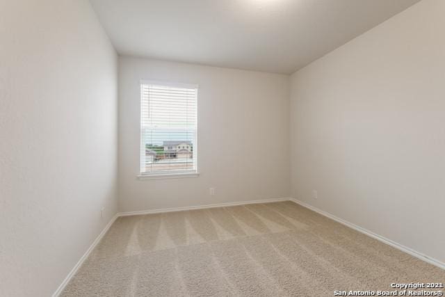 unfurnished room featuring light carpet