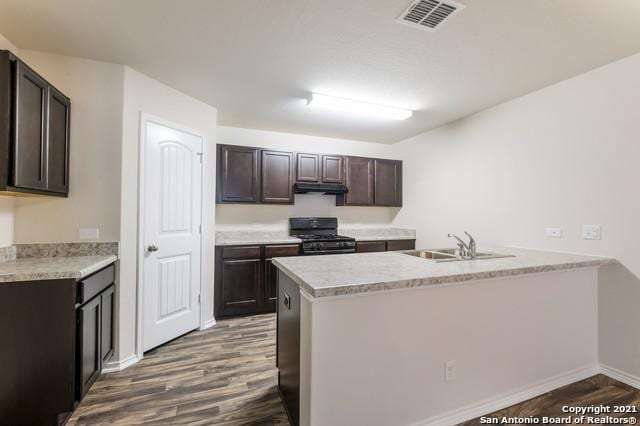 kitchen featuring sink, dark brown cabinetry, black range with gas cooktop, and dark wood-type flooring