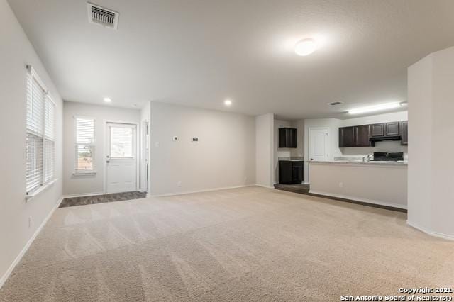 unfurnished living room with light colored carpet