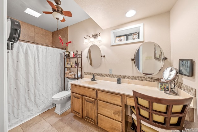 bathroom featuring vanity, tile patterned floors, ceiling fan, toilet, and a textured ceiling