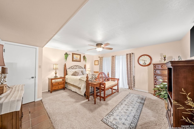 tiled bedroom featuring ceiling fan